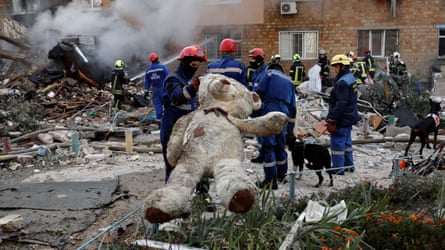 Emergency workers and a giant teddy bear rescued from the rubble