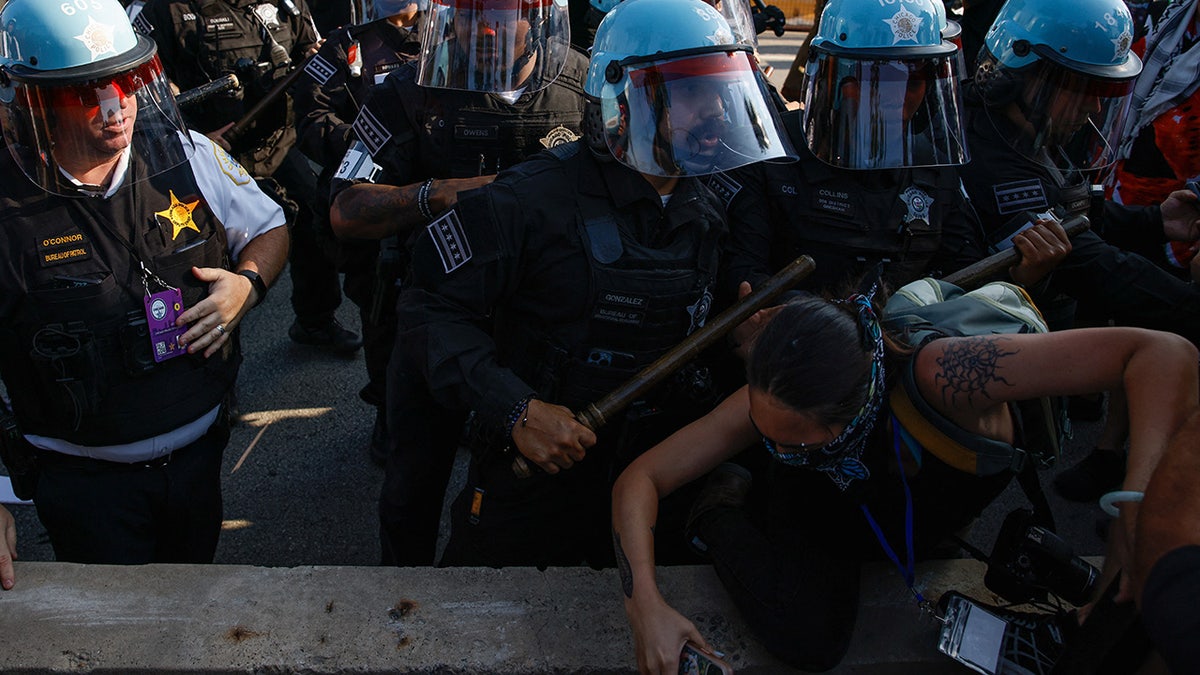 Riot police officers scuffle with demonstrators during the rally