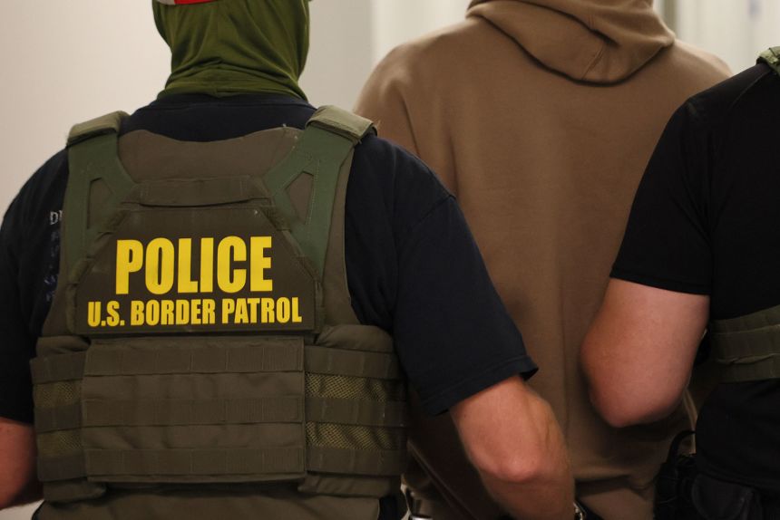 Federal agents detain a man after his court hearing in New York on July 9.