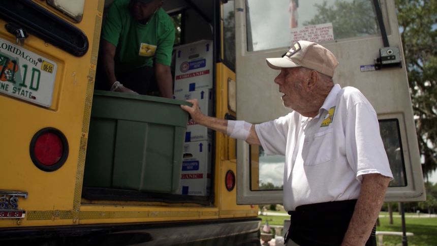 Bill Brown helps with a food delivery along the Children's Table weekly bus route.