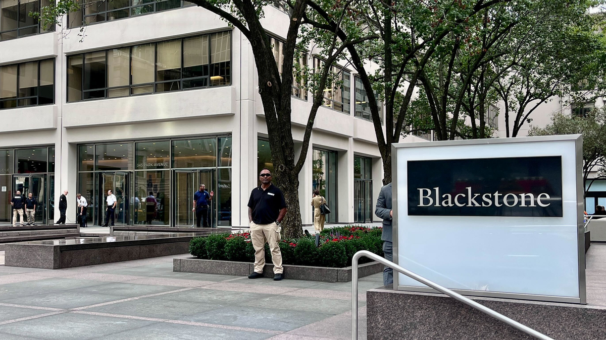 Security guards outside a building with a sign that says Blackstone
