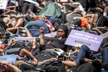 Protesters lie on the ground with a placard reading ‘end GBV and femicide now’