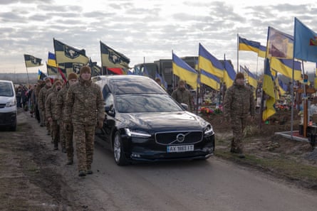 Soldiers march alongside a hearse