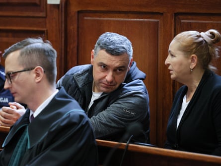 Two men and a woman sitting in panelled courtroom