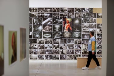 Annie Leibovitz photographs is displayed  on a wall at the MOP Foundation with a person walking past