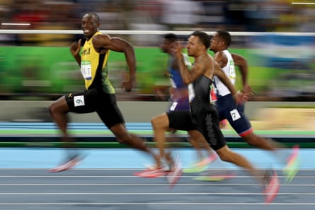 Usain Bolt of Jamaica, turning and appearing to smile at the camera, with other runners in the men’s 100 meter semifinal of the Rio 2016 Olympic Games, August 14 2016, in Rio de Janeiro, Brazil.
