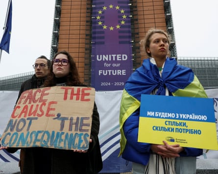 People demonstrate outside the European Commission in Brussels in support of using frozen Russian assets to finance Ukraine.