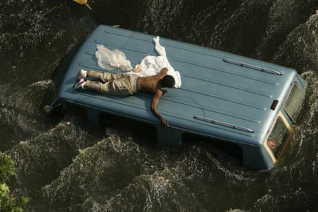 A man clings to the top of a vehicle in the flooded streets of New Orleans, in the aftermath of Hurricane Katrina, in Louisiana September 42005