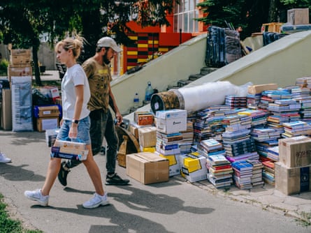 People near piles of books outside the building