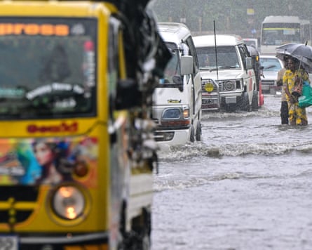 People wade through a flooded road in Biyagama, western Sri Lanka after Cyclone Ditwah decimated many parts of the country.