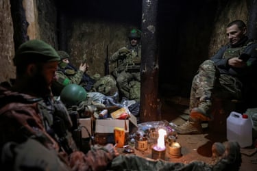 Servicemen sit in a dugout