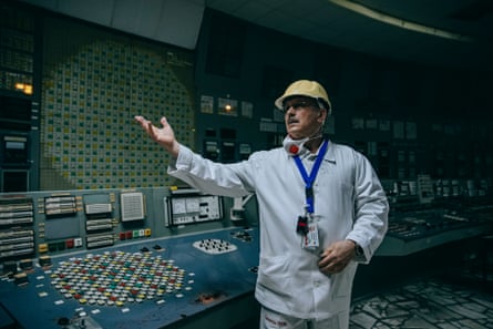 Oleksandr Skomarokhov in a yellow hard hat and overalls inside the control room
