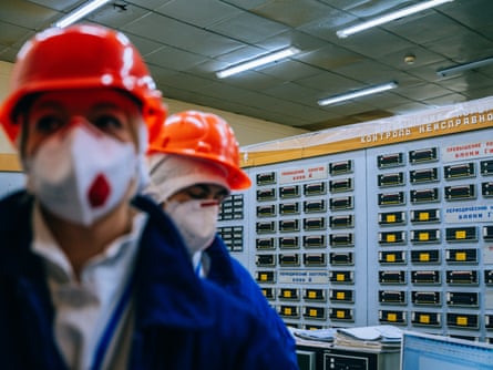 Two workers in red hard hats in one of the control rooms at Chornobyl.
