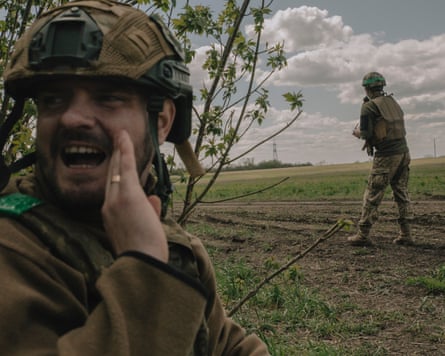Soldiers from the 148th brigade standing next to a hedge in a field