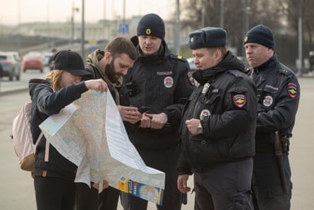 Police speak with a man and a woman carrying a paper map
