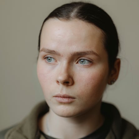 Closeup portrait of Kateryna Sheremeta, 16: she has very pale skin and blue-grey eyes, and straight, dark hair tied back. She looks serious and sombre.