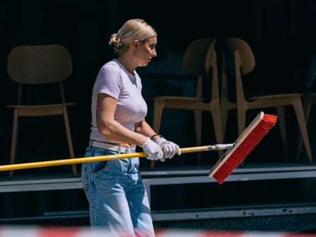 A woman in gloves holding a broom