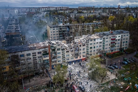 Rescuers atop a block of flats in Sloviansk that was partly destroyed by Russian shelling.