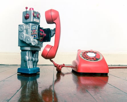 Big silver robot toy on the phone standing on an old wooden floor toned image