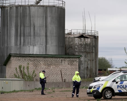 Police officers stand guard at an oil storage facility