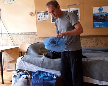 Oleksandr Pavlovych packs belongings into plastic bags at his temporary accommodation.