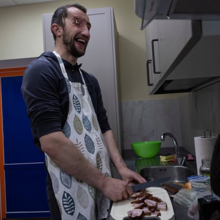 Andriy Onopriienko wearing an apron and preparing food in a kitchen