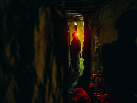 The silhouette of a man with head torch in a passageway.