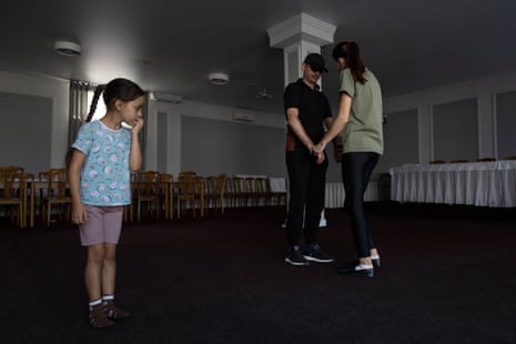 A young girl watches her father dance