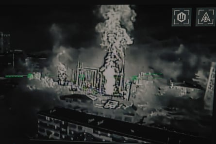 Black and white electronic camera footage of flames rising from a gateway