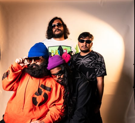 Four men in sunglasses and bright clothes pose for a portrait