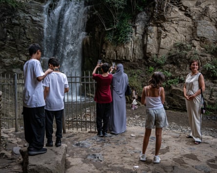 Tourists take photos in front of the Leghvtakhevi waterfall.