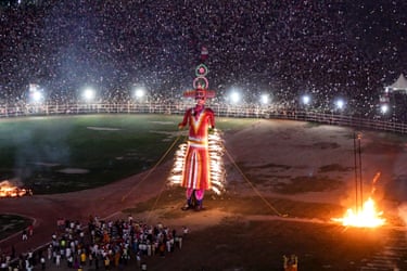 A towering Ravana effigy burns with sparks as huge crowds watch 