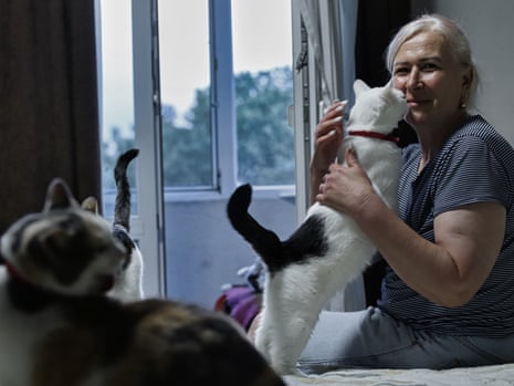 A middle-aged woman with three cats. 