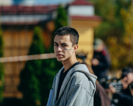 A man with a tattoo reading ‘immortal’ standing near the site of a Russian drone strike in Kyiv