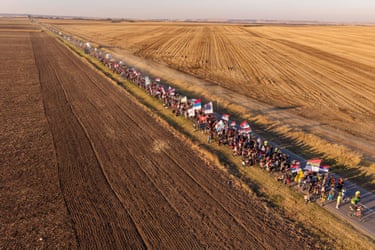 Aerial view of students marching with flags along a rural road